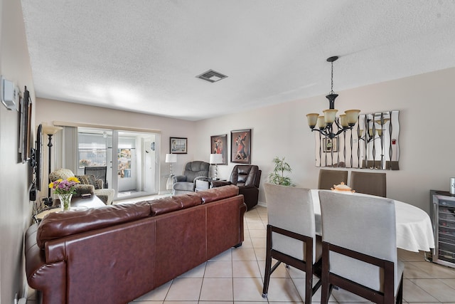 living room featuring wine cooler, a chandelier, a textured ceiling, and light tile patterned floors