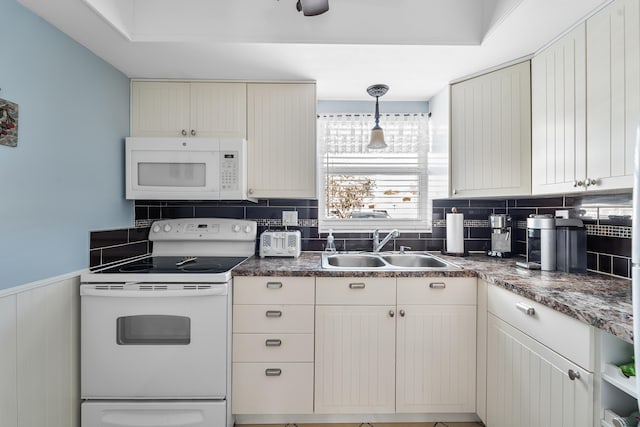 kitchen with sink, backsplash, hanging light fixtures, white appliances, and cream cabinetry