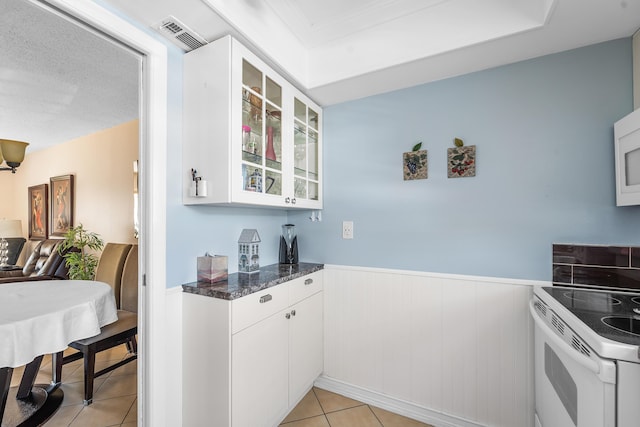 kitchen with white cabinetry, light tile patterned floors, and white range with electric stovetop