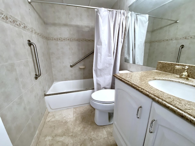 full bathroom featuring vanity, toilet, shower / bath combo with shower curtain, and tile walls