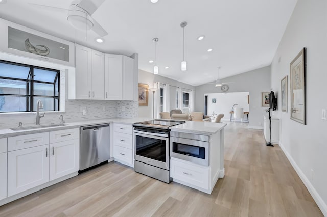 kitchen with white cabinetry, sink, hanging light fixtures, and appliances with stainless steel finishes