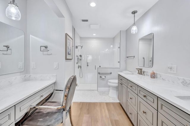 bathroom featuring walk in shower, vanity, toilet, and hardwood / wood-style floors