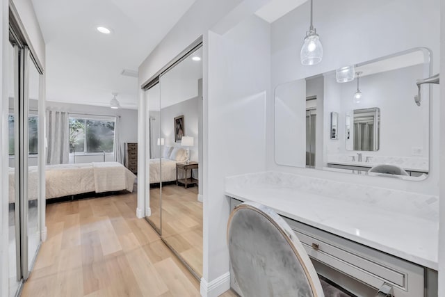 bathroom with ceiling fan, vanity, and hardwood / wood-style floors