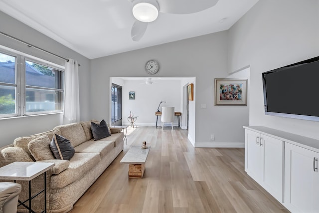 living room with ceiling fan, vaulted ceiling, and light hardwood / wood-style flooring