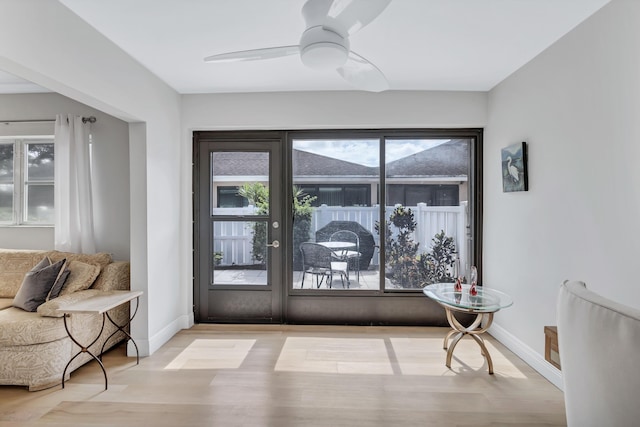 doorway featuring ceiling fan and light hardwood / wood-style flooring