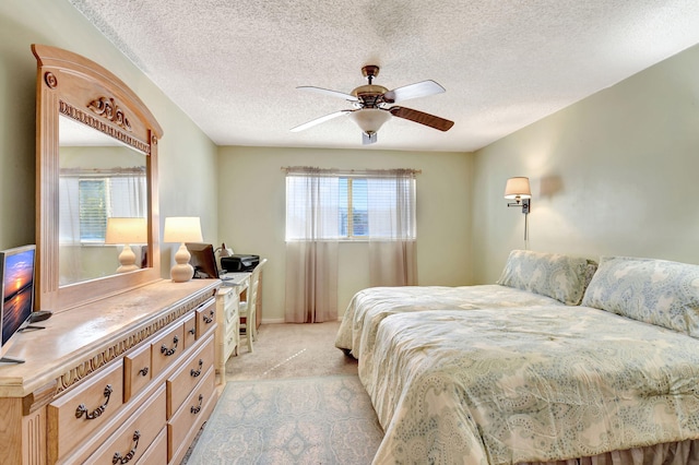 carpeted bedroom with ceiling fan and a textured ceiling