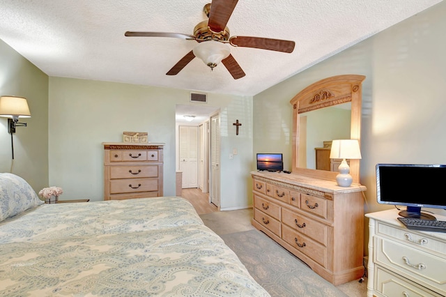 bedroom featuring ceiling fan and a textured ceiling