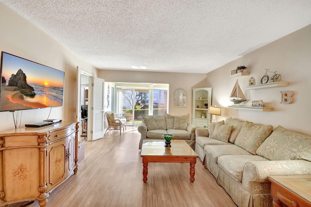 living room featuring a textured ceiling and light wood-type flooring