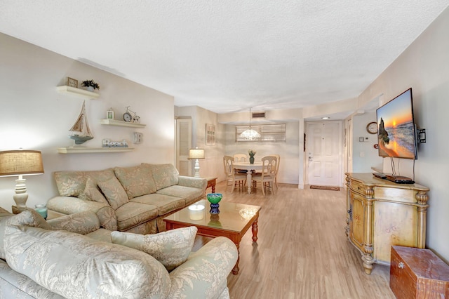 living room with a textured ceiling and light hardwood / wood-style flooring