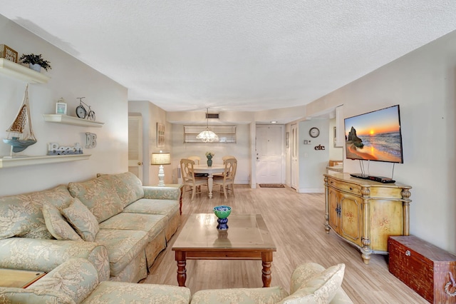 living room with light hardwood / wood-style floors and a textured ceiling