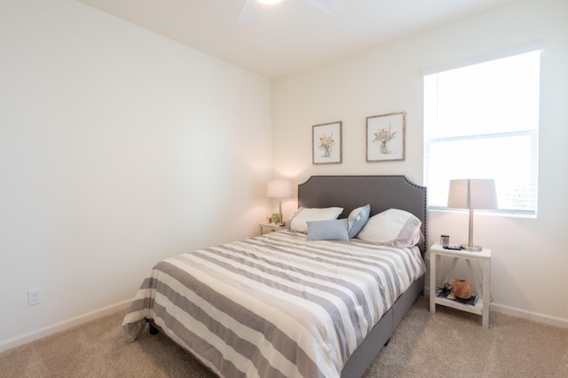 bedroom featuring light carpet and ceiling fan