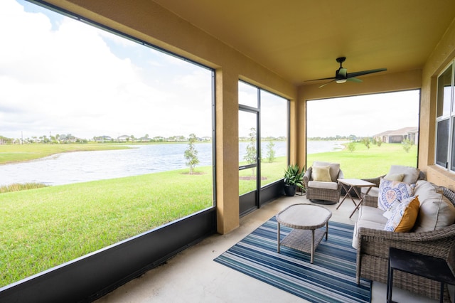 sunroom / solarium featuring ceiling fan and a water view