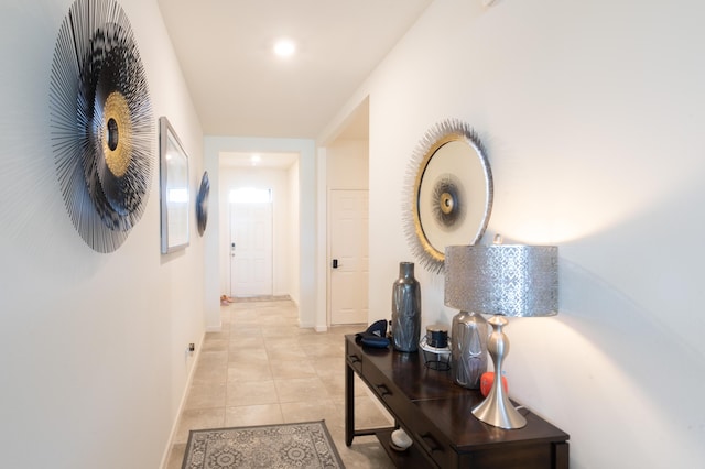 hall with baseboards and light tile patterned floors