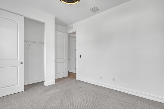 unfurnished bedroom with light carpet and a closet