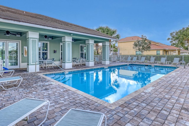 view of swimming pool with ceiling fan and a patio area