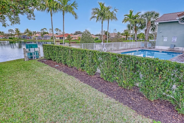 view of swimming pool with a yard and a water view