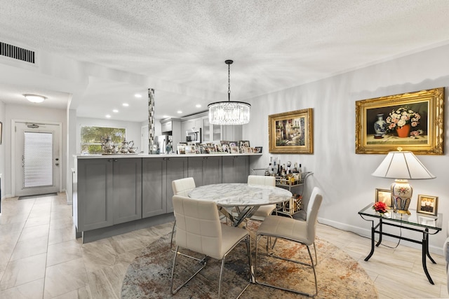 dining room featuring a textured ceiling and a notable chandelier