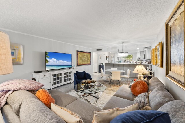 living room featuring a textured ceiling and a notable chandelier