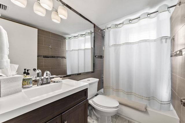 full bathroom with tile walls, vanity, shower / tub combo, and toilet