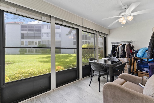 sunroom / solarium featuring ceiling fan