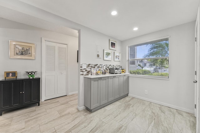 kitchen featuring tasteful backsplash and gray cabinets