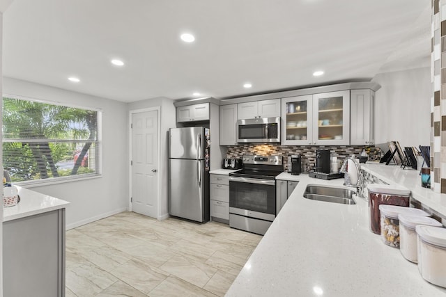 kitchen with gray cabinetry, sink, and stainless steel appliances