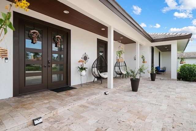 11951 Torreyanna Cir, Palm Beach Gardens, FL 33412 - view of exterior entry with french doors, a patio area, a tiled roof, and stucco siding