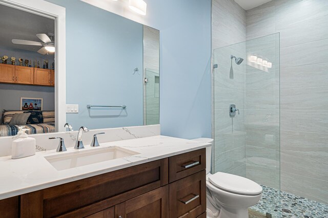 11951 Torreyanna Cir, Palm Beach Gardens, FL 33412 - bathroom featuring vanity, tiled shower, connected bathroom, and toilet