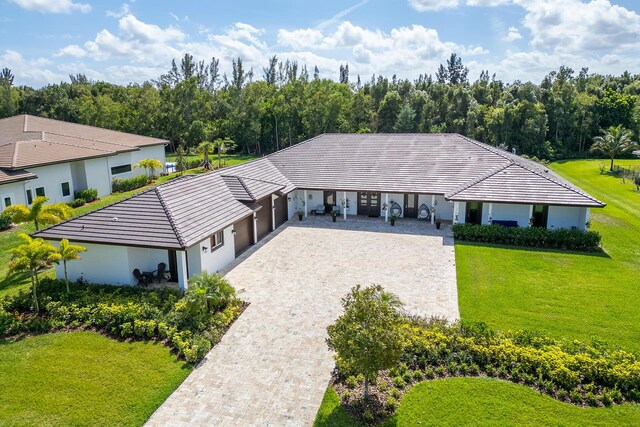 11951 Torreyanna Cir, Palm Beach Gardens, FL 33412 - view of front facade featuring decorative driveway, a tiled roof, and a front lawn