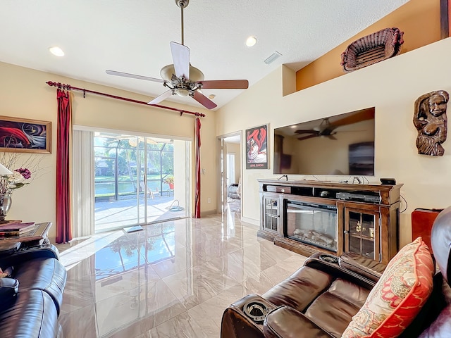 living room with lofted ceiling, a textured ceiling, and ceiling fan