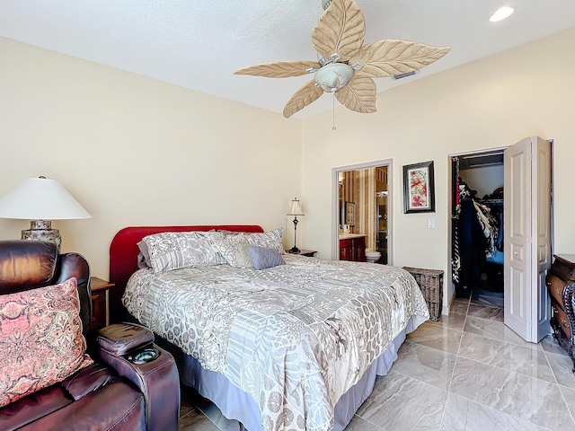 bedroom with ceiling fan, ensuite bathroom, a spacious closet, and a closet