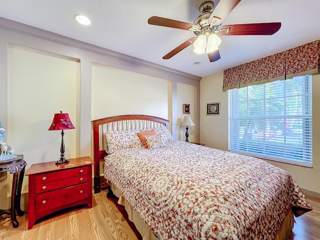 bedroom with ceiling fan, a textured ceiling, and light hardwood / wood-style floors