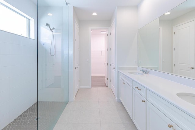 bathroom featuring tile patterned flooring, vanity, and tiled shower