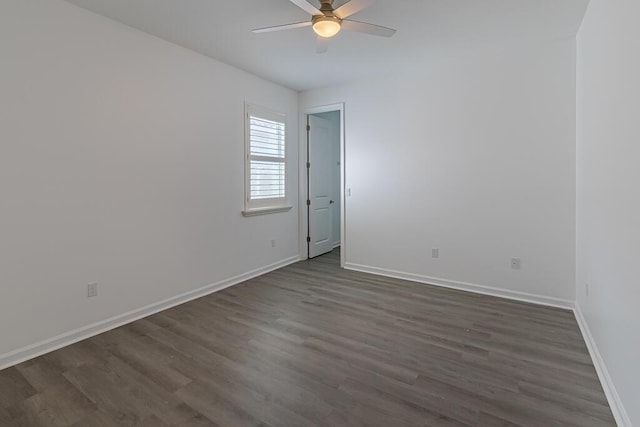 spare room with dark wood-type flooring and ceiling fan