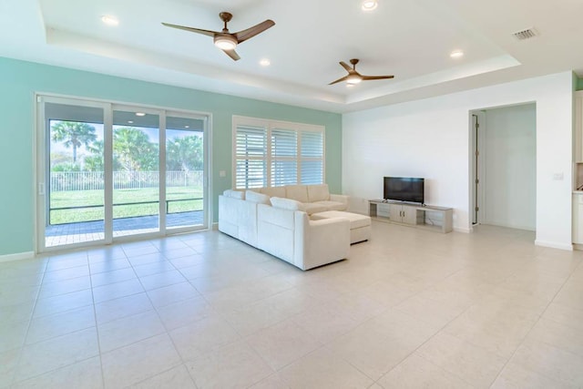 unfurnished living room featuring light tile patterned floors, a tray ceiling, and ceiling fan