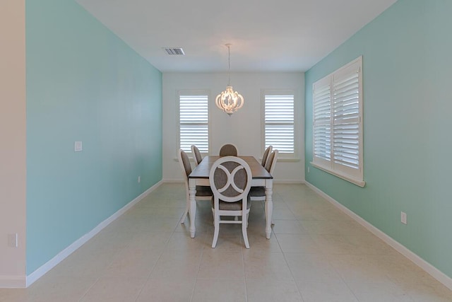 tiled dining area featuring a notable chandelier