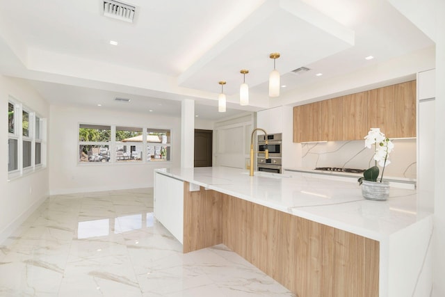 kitchen with visible vents, modern cabinets, light stone counters, hanging light fixtures, and backsplash