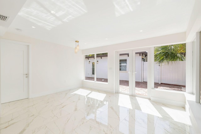 spare room with marble finish floor, baseboards, visible vents, and french doors