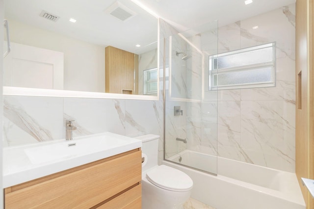 bathroom featuring visible vents, toilet, vanity, and enclosed tub / shower combo