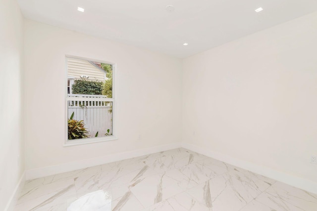 empty room featuring marble finish floor, baseboards, and recessed lighting