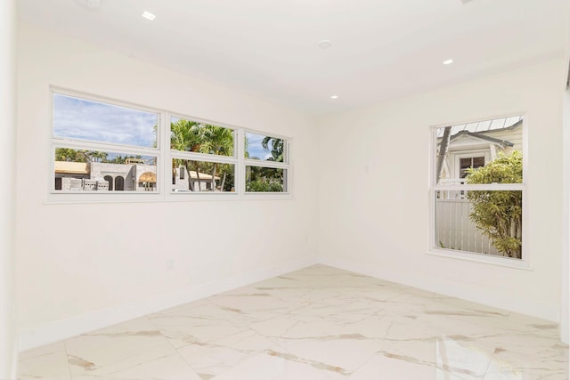 empty room featuring marble finish floor, baseboards, and recessed lighting