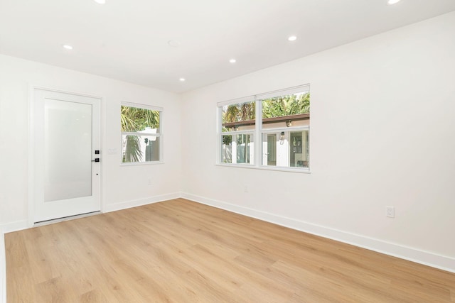 unfurnished room featuring baseboards, light wood finished floors, and recessed lighting