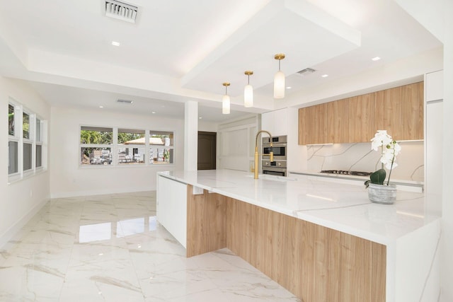 kitchen with modern cabinets, visible vents, light stone counters, a raised ceiling, and baseboards