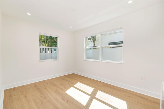 empty room with recessed lighting, light wood finished floors, and baseboards