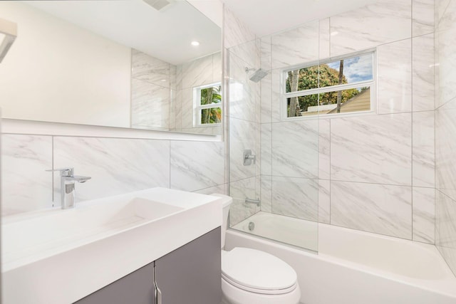 bathroom with bath / shower combo with glass door, vanity, tile walls, and toilet