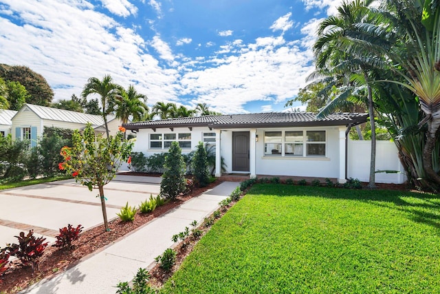 ranch-style house with stucco siding, a tiled roof, fence, and a front lawn
