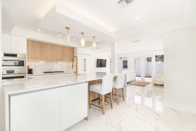 kitchen featuring visible vents, modern cabinets, double oven, recessed lighting, and gas cooktop