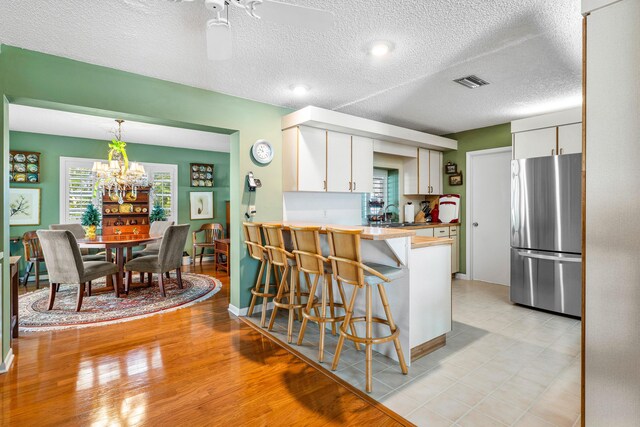 1210 Dolphin Rd, Singer Island, FL 33404 - kitchen featuring a peninsula, freestanding refrigerator, white cabinets, and a sink