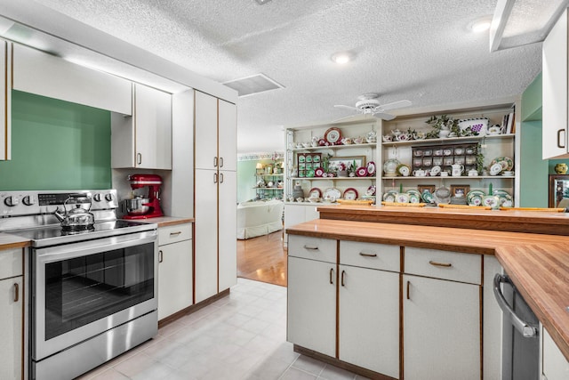 kitchen featuring wood counters, white cabinetry, stainless steel range with electric cooktop, ceiling fan, and a textured ceiling