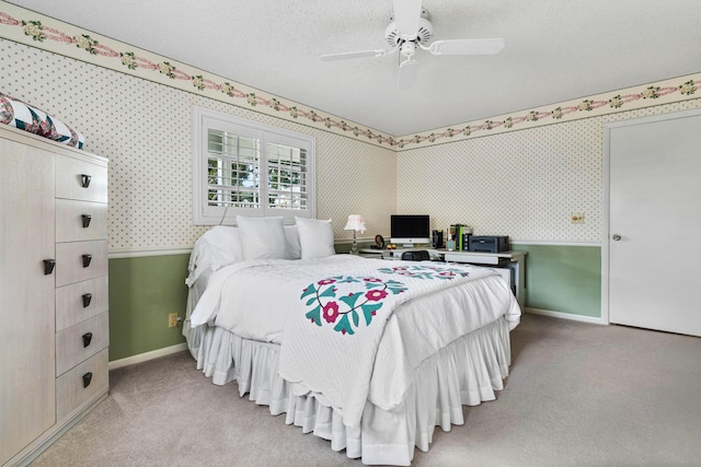 bedroom featuring ceiling fan, light colored carpet, and a textured ceiling